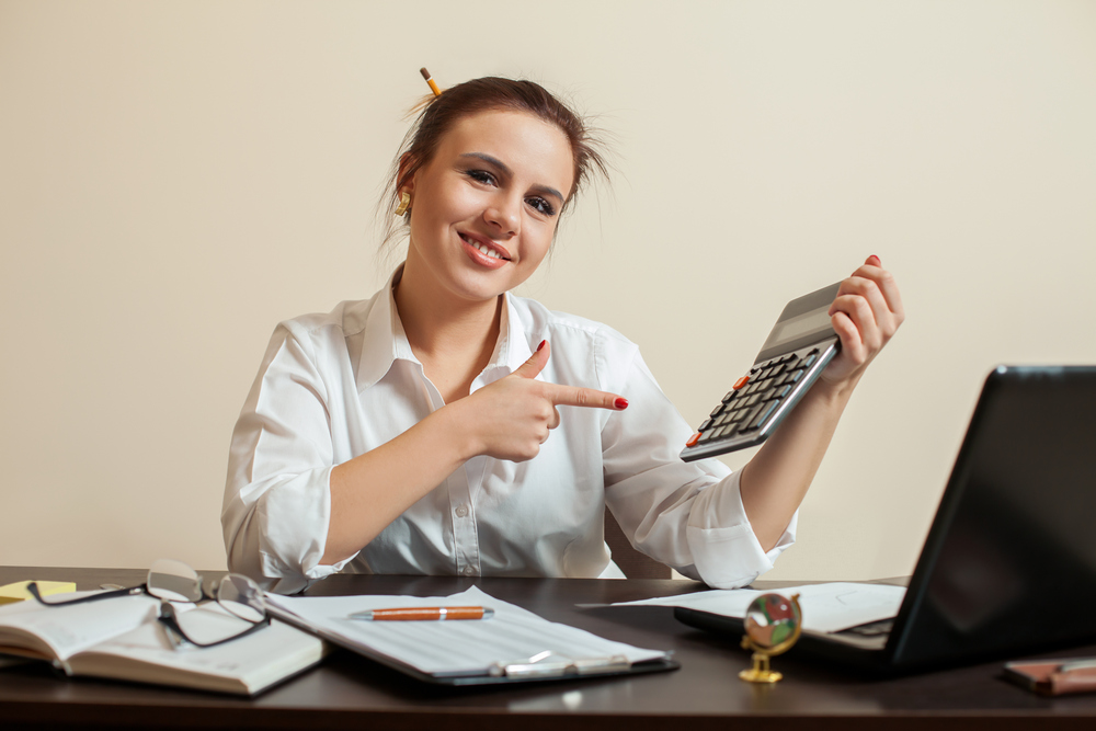 Happy young female accountant with calculator